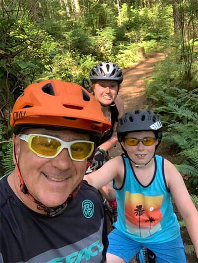 Charlie and his family riding bikes on a trail